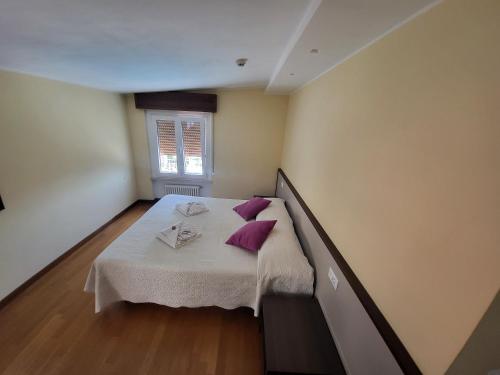 a bedroom with a bed with purple pillows on it at Penthouse CASA ALKEA Masse Lake view in Brenzone sul Garda
