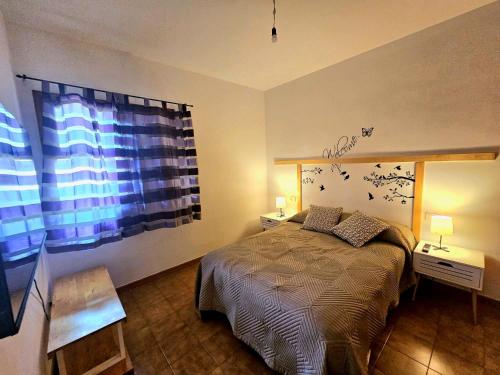 1 dormitorio con cama y ventana grande en Brisas del Roque Coastline Apartment in Garachico by HRTenerife Net en Garachico