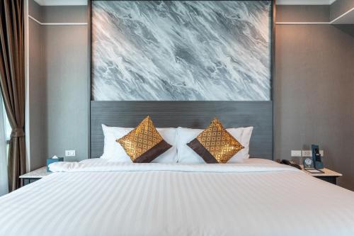 a bedroom with a large bed with two pillows at Siam Mandarina Hotel - Free BKK Airport Shuttle in Lat Krabang