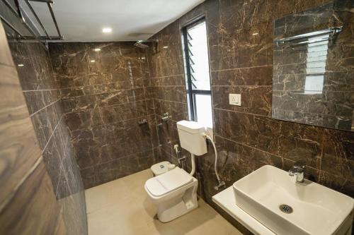 a bathroom with a toilet and a sink at Hotel Shertown in Ahmedabad