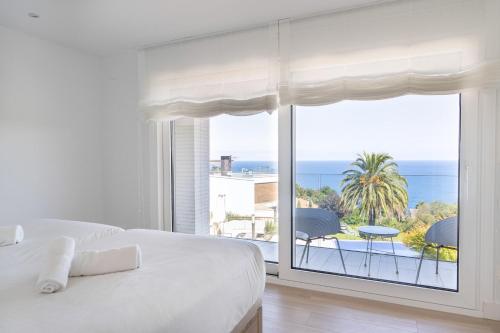 a white bedroom with a view of the ocean at Boutique Ocean Terrace Luxury II - SSHOUSING in Igueldo