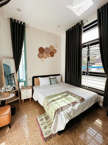 a bedroom with a bed and a large window at Under the Sun Homestay in Hue