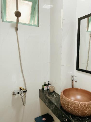 a bathroom with a copper sink and a mirror at Under the Sun Homestay in Hue