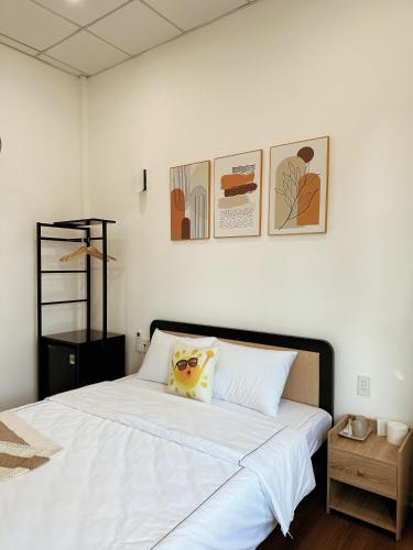 a bedroom with a large white bed with two pillows at Under the Sun Homestay in Hue
