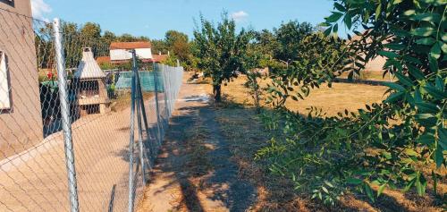 a fence in front of a yard with trees at Villa Ginzo in Verín