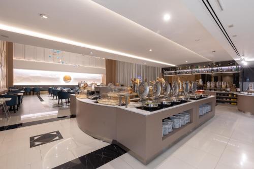 a restaurant with a counter and tables and chairs at Siam Mandarina Hotel - Free BKK Airport Shuttle in Lat Krabang