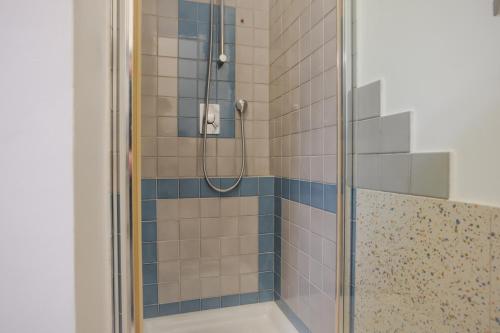 ein Badezimmer mit einer Dusche mit blauen und weißen Fliesen in der Unterkunft B&B Vatican Stories in Rom