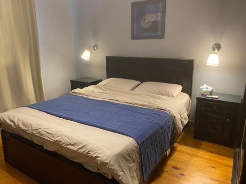 una camera da letto con un grande letto con una coperta blu di A cosy Apartment just for you to relax a Città del 6 ottobre
