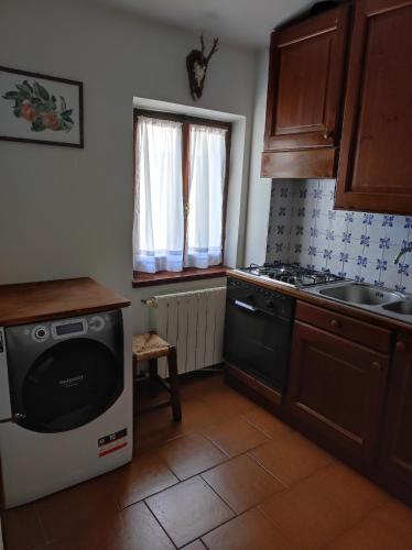 a kitchen with a dishwasher and a sink and a stove at Appartamento Belvedere Abetone in Abetone