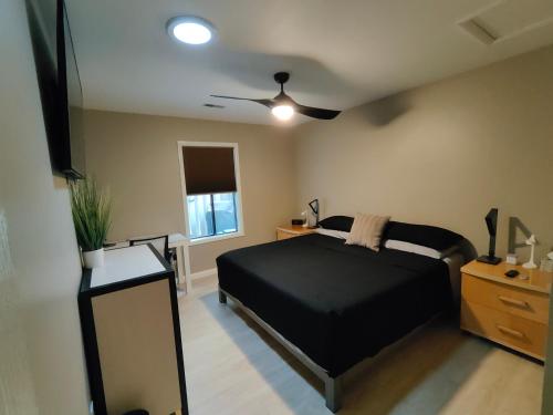 1 dormitorio con cama negra y ventilador de techo en Modern/Retro Condo en High Point