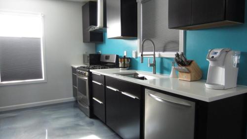 a kitchen with a sink and a stove top oven at Modern/Retro Condo in High Point