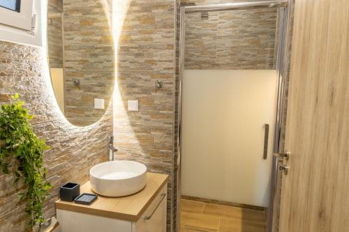 La salle de bains est pourvue d'un lavabo et d'un miroir. dans l'établissement Bardis Hidden Gem, à Vólos