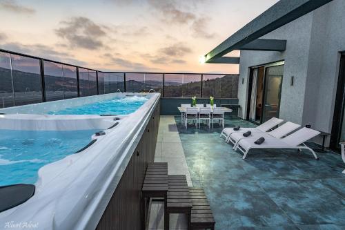 a swimming pool with a table and chairs on a building at סוויטות בוטיק נעמי in Netu'a