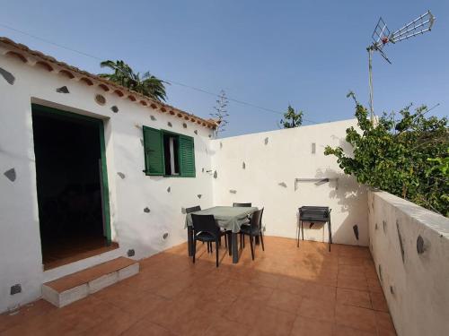 a patio with a table and chairs next to a building at Rinconcito Rural con encanto en Las Hayas by Vapagó Tenerife in Acardece
