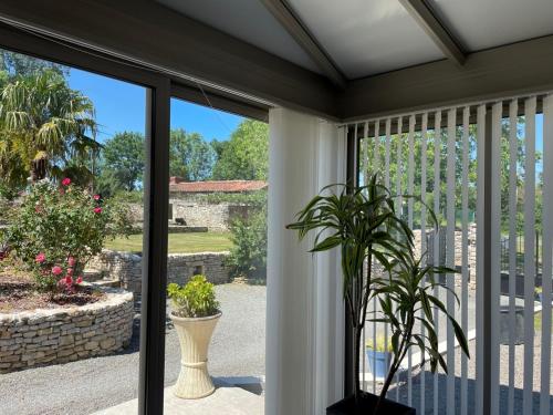 a sliding glass door to a patio with a plant at La Frouardière, 3 gîtes de charme in Antigny