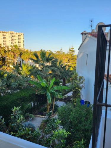 a view of a courtyard with palm trees from a balcony at DELUXE Studio ATHOS 50 MP Garden patio BENALMADENA Golf & Beach in Benalmádena
