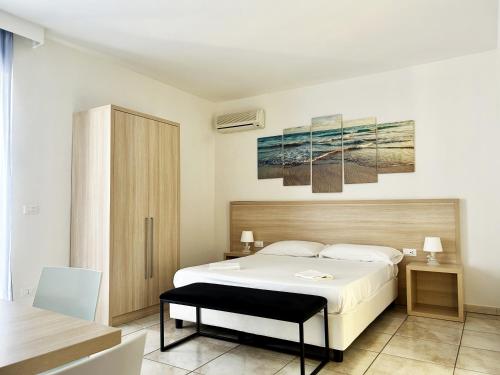 Un dormitorio con una gran cama blanca y una mesa en Resort Park Village, en Rossano