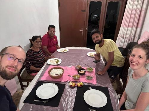 a group of people sitting around a table eating food at Dreamscape home stay in Kandy