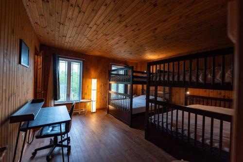 a room with two bunk beds and a desk at Chalet in a dark sky reserve in Notre-Dame-Des-Bois