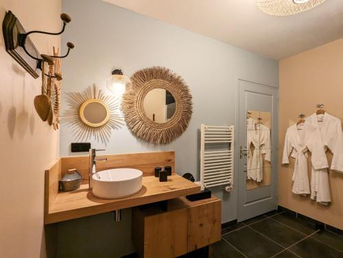 une salle de bain avec un lavabo et un miroir dans l'établissement Le clos des pierres rouges, à Saint-Privat-dʼAllier