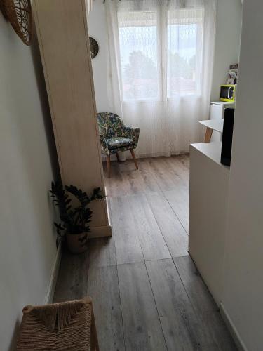 ein Wohnzimmer mit Holzboden und einem Stuhl in der Unterkunft Le cocooning in Berre-lʼÉtang