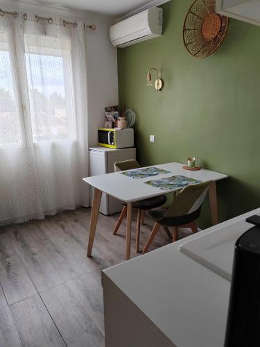 eine Küche mit einem Tisch und Stühlen im Zimmer in der Unterkunft Le cocooning in Berre-lʼÉtang
