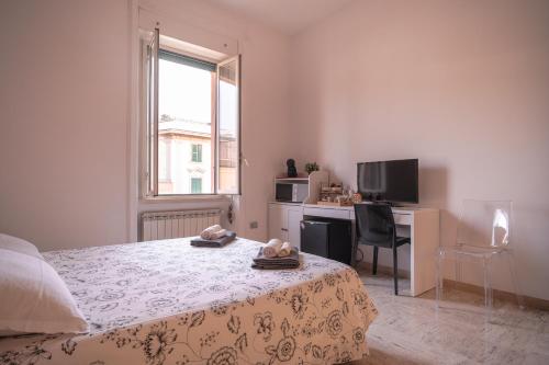ein Schlafzimmer mit einem Bett, einem Schreibtisch und einem Fenster in der Unterkunft B&B Vatican Stories in Rom