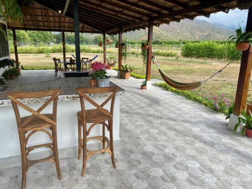 a patio with two chairs and a table and a hammock at Beautiful Private Villa, Views in Every Direction in Bolívar