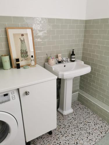 a bathroom with a sink and a washing machine at Home sweet home in Paris
