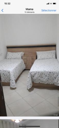 twee bedden naast elkaar in een kamer bij Mbari in Martil