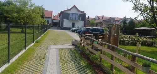 a driveway leading to a house with a fence at Mini Apartament Rynek in Zakliczyn