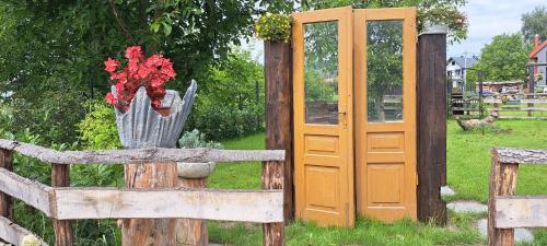an orange door and a fence with flowers on it at Mini Apartament Rynek in Zakliczyn