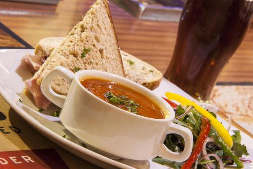 
a sandwich and a cup of soup on a plate at Poolewe Hotel in Poolewe
