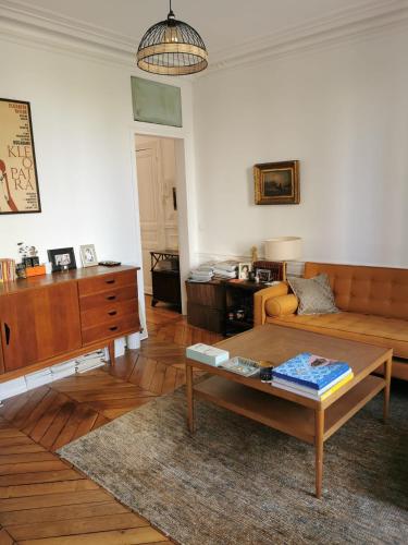 a living room with a couch and a table at Home sweet home in Paris