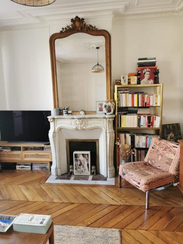 a living room with a fireplace and a mirror at Home sweet home in Paris