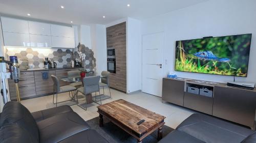 un salon avec un canapé, une télévision et une table dans l'établissement Apt 2 Chambres - Direct Gare Part-Dieu, Lyon - Ascenseur & Wi-Fi Gratuit, à Lyon