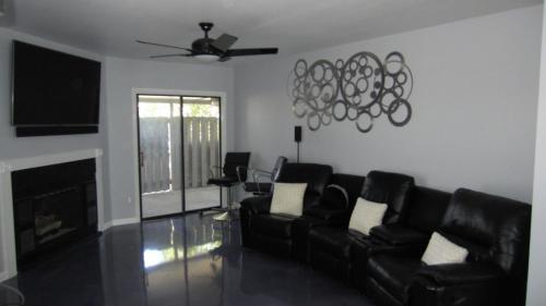 a living room with black leather furniture and a fireplace at Modern/Retro Condo in High Point
