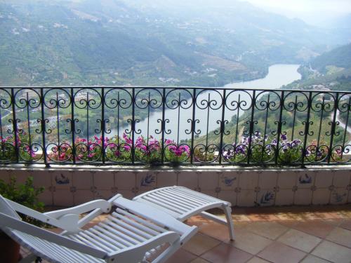 a white bench sitting on a balcony overlooking a river at Casa De Canilhas in Mesão Frio