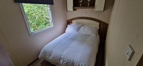 a small bedroom with a bed with a window at A5 Avocet Rise in Paignton