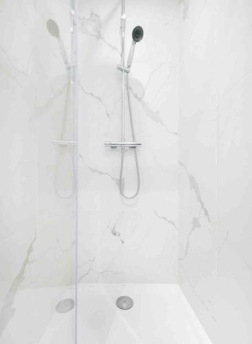 une salle de bain avec une douche avec une porte vitrée dans l'établissement Appartement neuf • Cosy et Lumineux • 4 personnes, à Marseille