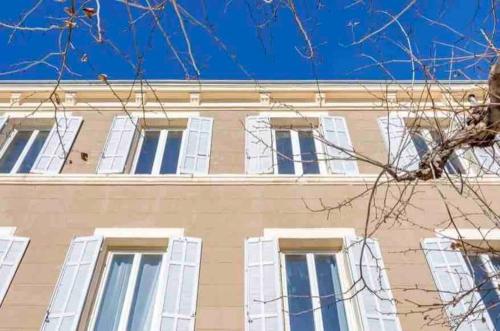un bâtiment avec des fenêtres blanches et un ciel bleu dans l'établissement Appartement neuf • Cosy et Lumineux • 4 personnes, à Marseille