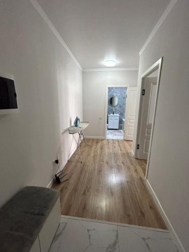 een lege kamer met witte muren en een houten vloer bij 1 комнатная квартира Аппартаменты ЖК Aspan city in Alma-Ata