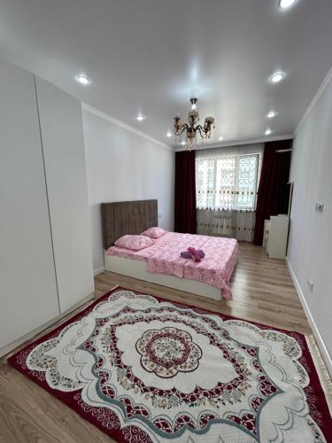 um quarto com uma cama rosa e um tapete em 1 комнатная квартира Аппартаменты ЖК Aspan city em Almaty