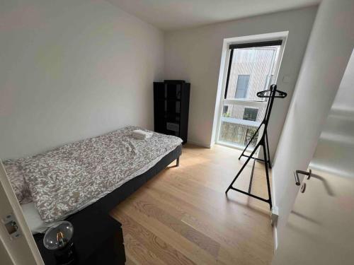 Un dormitorio con una cama y un trípode. en Charmerende 3-værelses lejlighed en Copenhague