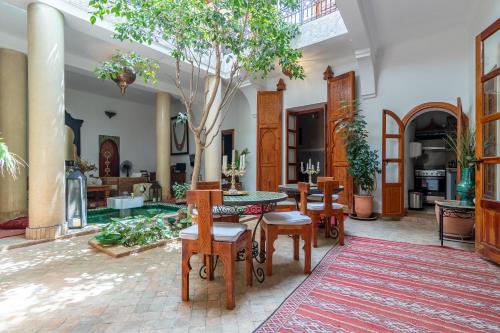 una sala de estar con una mesa y un árbol. en Riad Dar Kasal en Marrakech