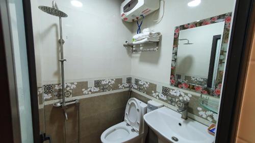 a bathroom with a toilet and a sink and a mirror at Sơn Tùng Hostel in Cat Ba