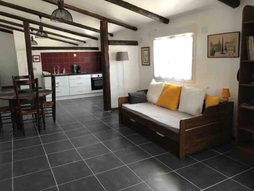 un salon avec un canapé et une cuisine dans l'établissement Logement insolite au coeur d'une écurie, à Arles