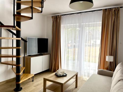Televízia a/alebo spoločenská miestnosť v ubytovaní Apartamenty Lobeliowy Port