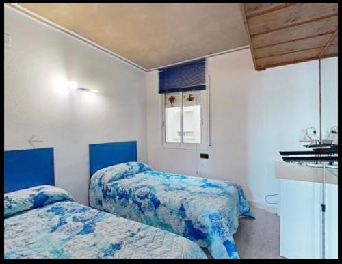 サロウにあるApartamento Salou Port Aventuraの青と白の部屋のベッド2台