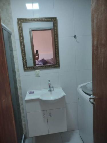 uma casa de banho branca com um lavatório e um espelho em Apartamento em Copacabana no Rio de Janeiro